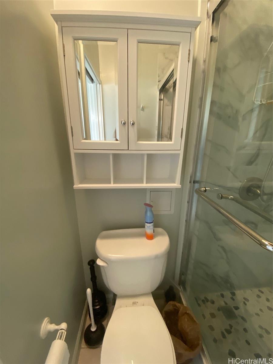 45-315 Lilipuna Road, Unit A306 Kaneohe, HI 96744 - Photo 14 of 19 a bathroom with a toilet a sink and a mirror