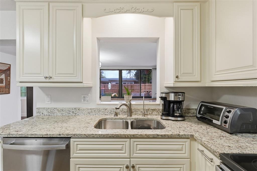 1130 8th Avenue Northeast Largo, FL 33770 - Photo 15 of 39 a kitchen with granite countertop white cabinets and a sink