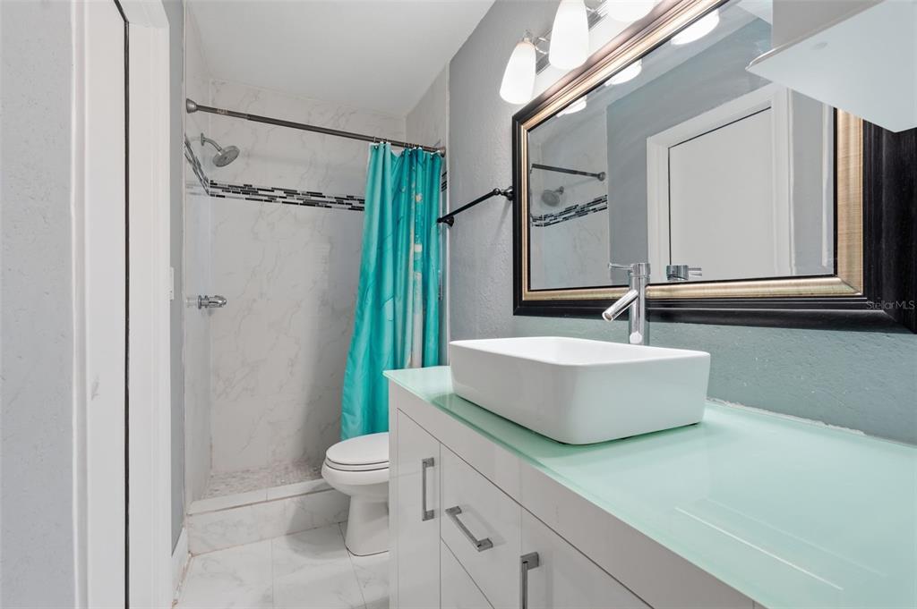 1130 8th Avenue Northeast Largo, FL 33770 - Photo 28 of 39 a bathroom with a double vanity sink toilet mirror and shower