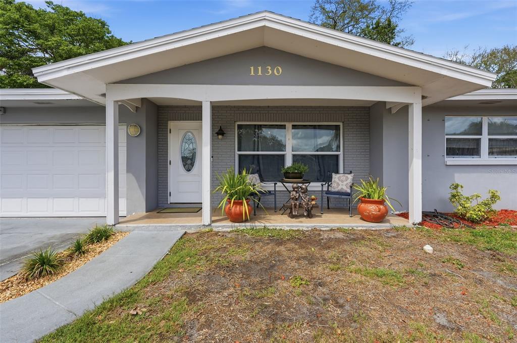 1130 8th Avenue Northeast Largo, FL 33770 - Photo 5 of 39 a front view of a house with patio outdoor seating and yard