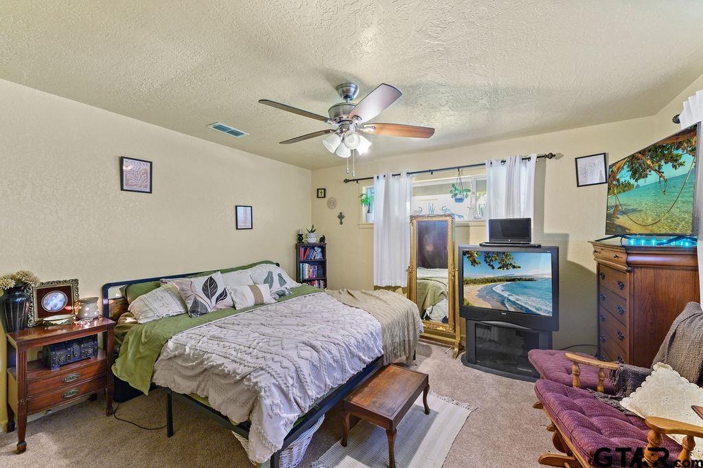 509 Tina Street Quitman, TX 75783 - Photo 11 of 17 a bedroom with a bed and a chandelier