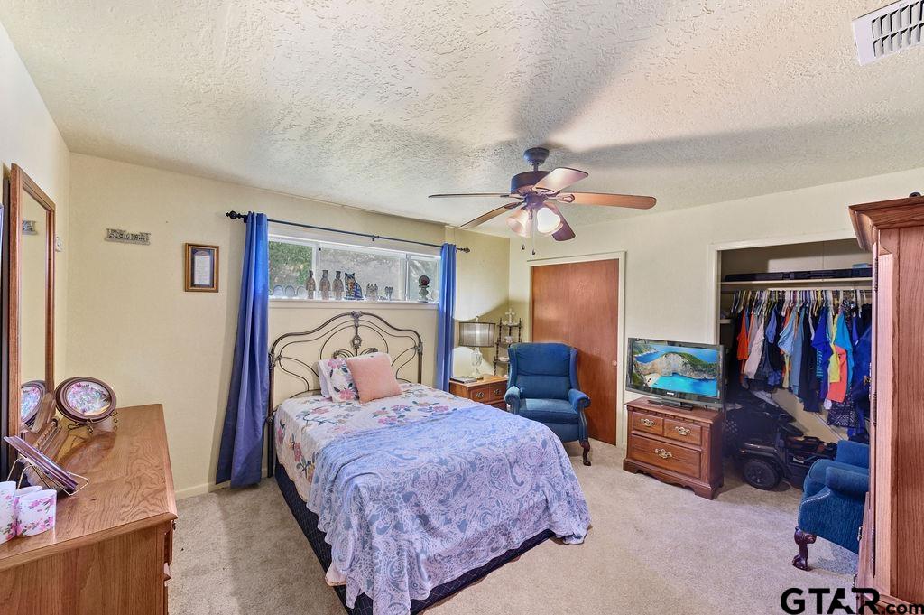 509 Tina Street Quitman, TX 75783 - Photo 9 of 17 a bedroom with a bed and a walk in closet