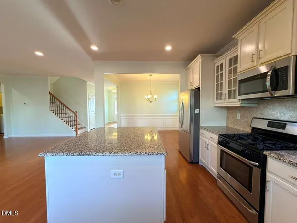 a kitchen with kitchen island granite countertop a stove and a sink