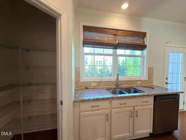 a kitchen with granite countertop a sink and a white cabinets