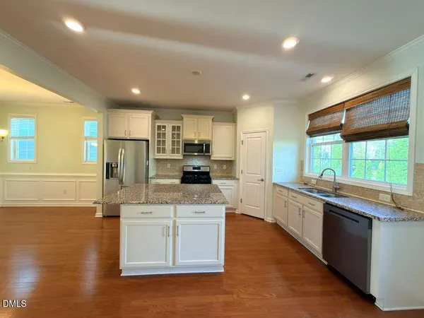 a large kitchen with stainless steel appliances kitchen island granite countertop a stove and a sink
