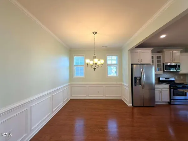 a view of a kitchen with a sink refrigerator and wooden floor
