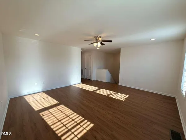 a view of an empty room and a ceiling fan