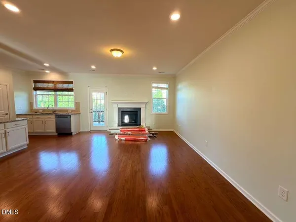 a view of empty room with a fireplace and wooden floor