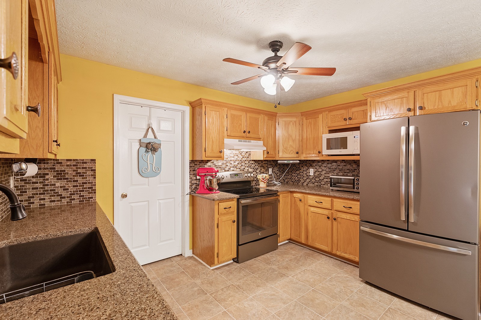 4415 Matthews Road Cedar Hill, TN 37032 - Photo 7 of 19 a kitchen with stainless steel appliances granite countertop a refrigerator a stove a sink and a microwave
