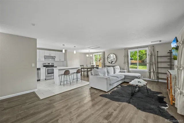 a living room with fireplace furniture and a large window