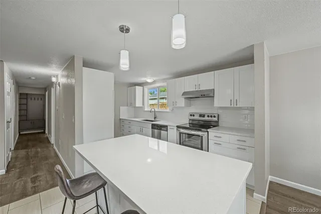 a kitchen with kitchen island a stove a table and chairs in it