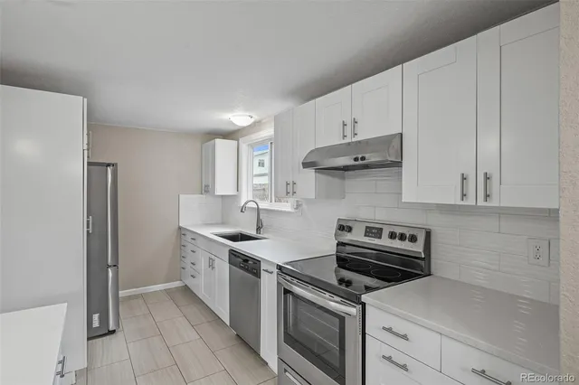 a kitchen with a stove sink and refrigerator