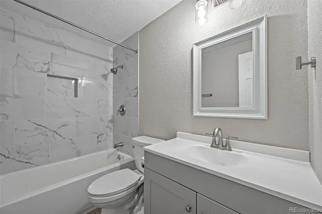 a bathroom with a toilet a sink a mirror a bathtub and shower