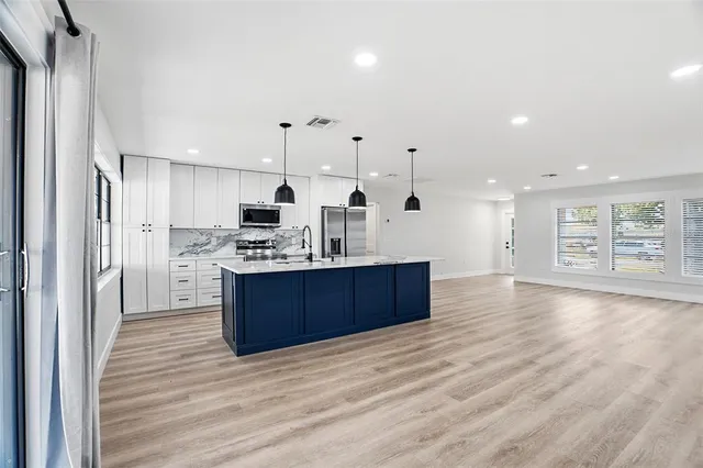 a kitchen with stainless steel appliances kitchen island wooden cabinets and granite counter tops