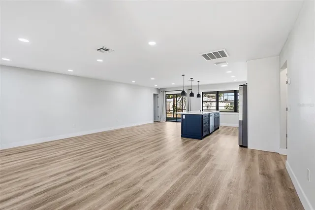a kitchen with stainless steel appliances granite countertop a sink a stove and a wooden floors