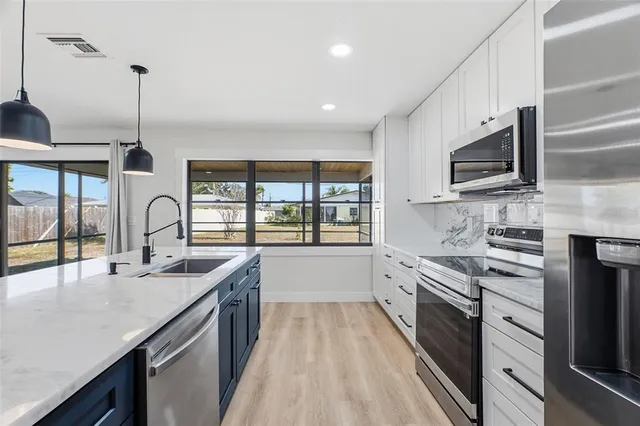 a large kitchen with kitchen island a sink stainless steel appliances and cabinets