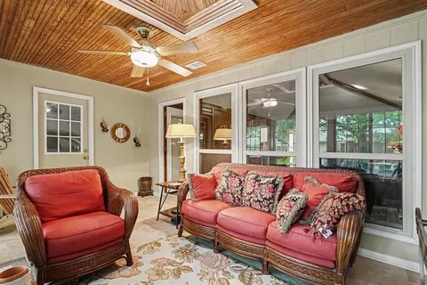 a living room with furniture a flat screen tv and windows