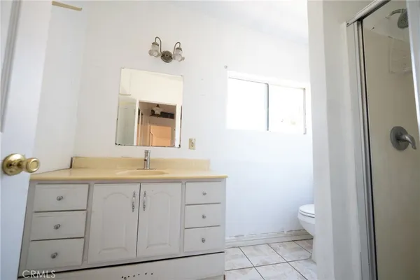 a bathroom with a granite countertop sink a toilet and a mirror