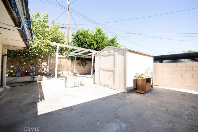 a view of a patio with couches and table and chairs under an umbrella