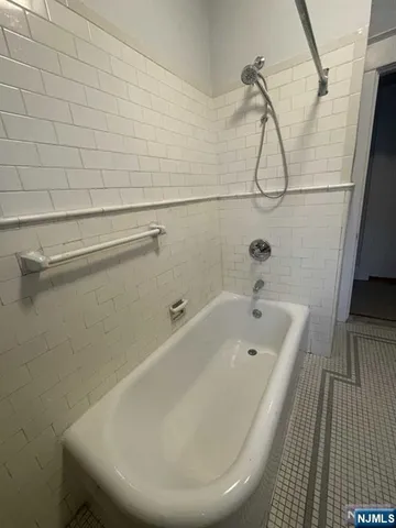 a bathroom with a white bath tub and a shower