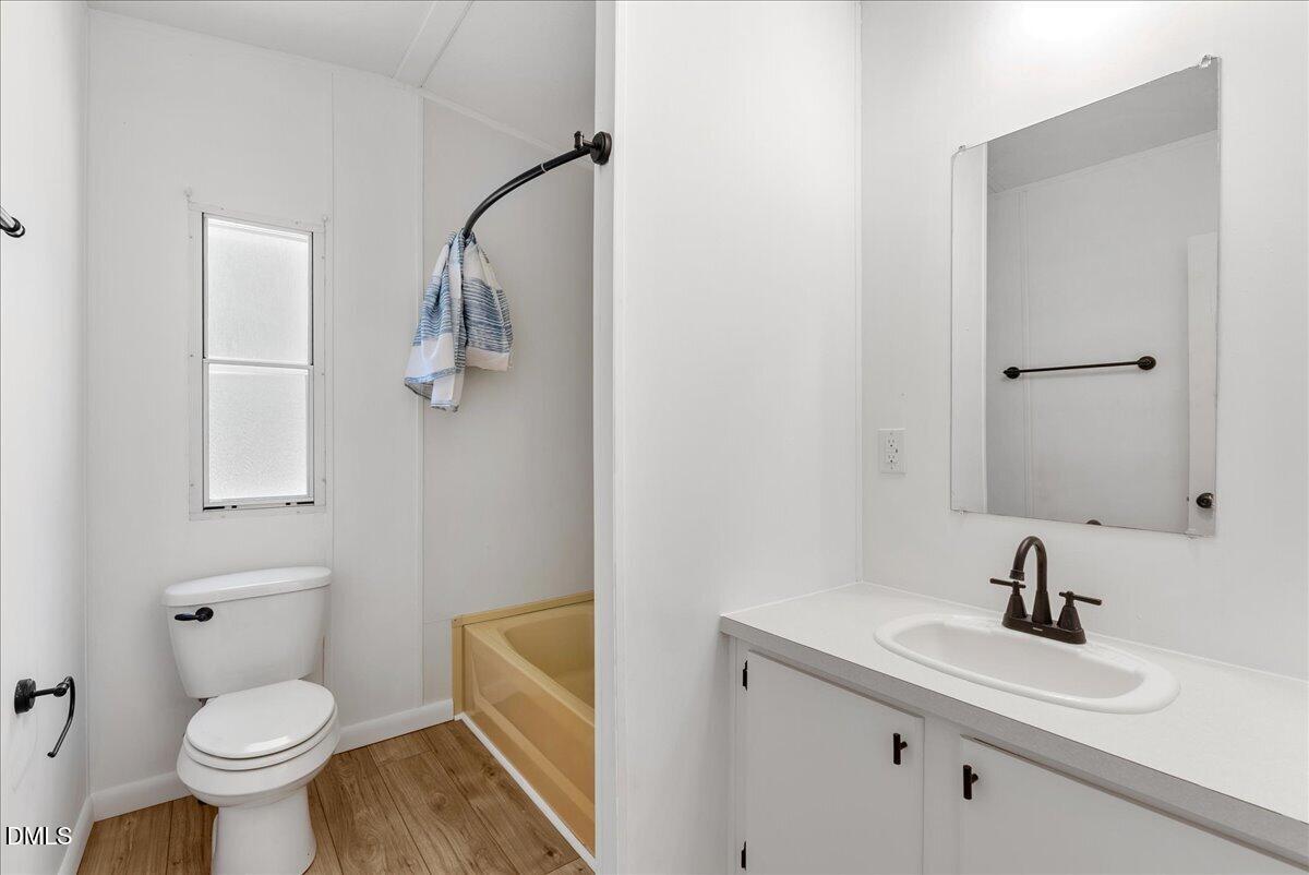 1111 Stoney Mountain Road Rougemont, NC 27572 - Photo 13 of 30 a bathroom with a sink toilet a mirror and vanity