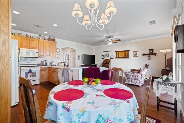 a kitchen with stainless steel appliances wooden floor dining table and chairs