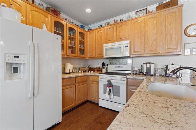 a kitchen with stainless steel appliances granite countertop a stove a sink and a refrigerator