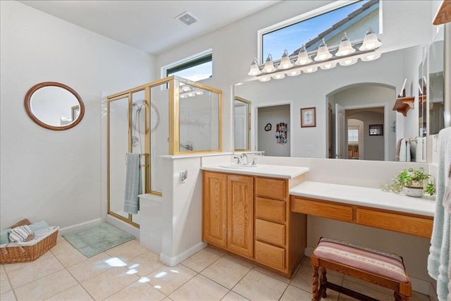 a spacious bathroom with a granite countertop sink a mirror and a shower