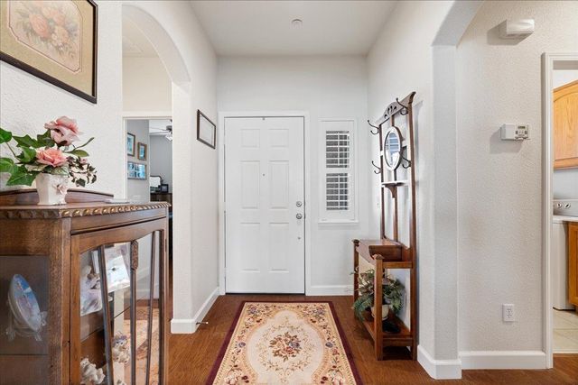 a view of a hallway with wooden floor and a livingroom
