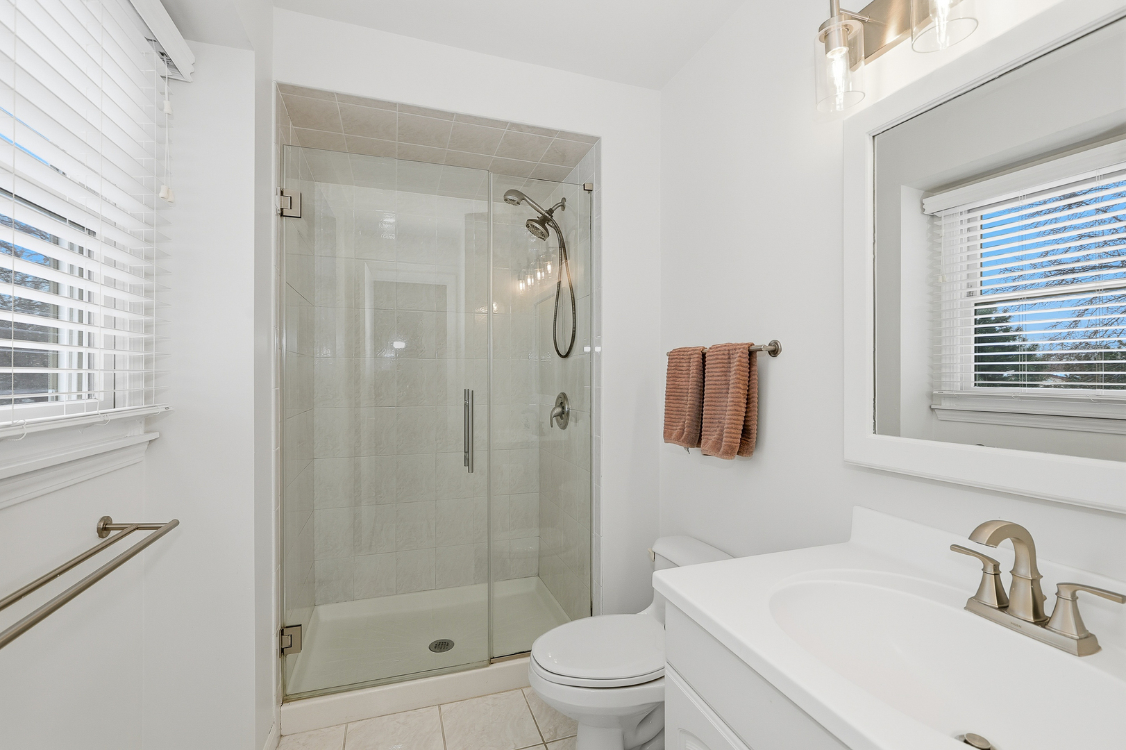 7209 Grant Street Darien, IL 60561 - Photo 24 of 37 a bathroom with a shower a sink a toilet and a window