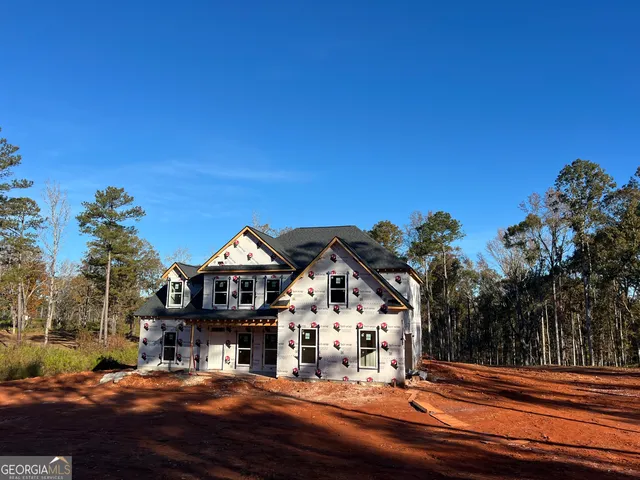 a view of a big house with a big yard and large trees