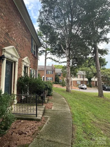 a view of a yard with plants and trees