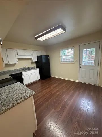 a kitchen with granite countertop wooden floors and wide window