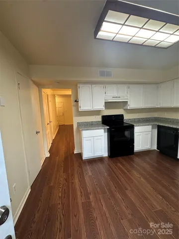 a kitchen with wooden floors and appliances