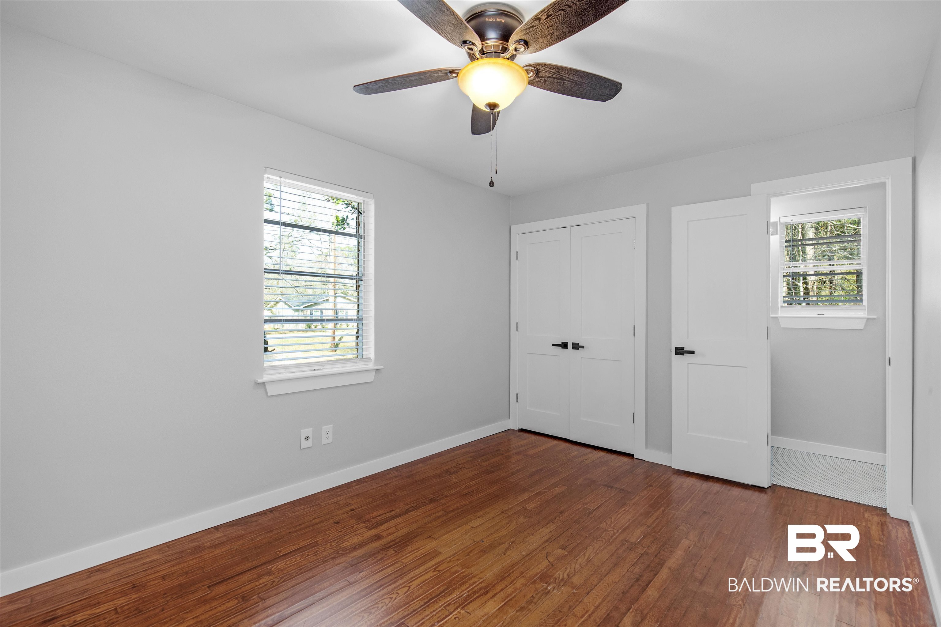 3005 Club House Road Mobile, AL 36605 - Photo 12 of 20 Unfurnished bedroom featuring multiple windows, a closet, ceiling fan, and wood-type flooring