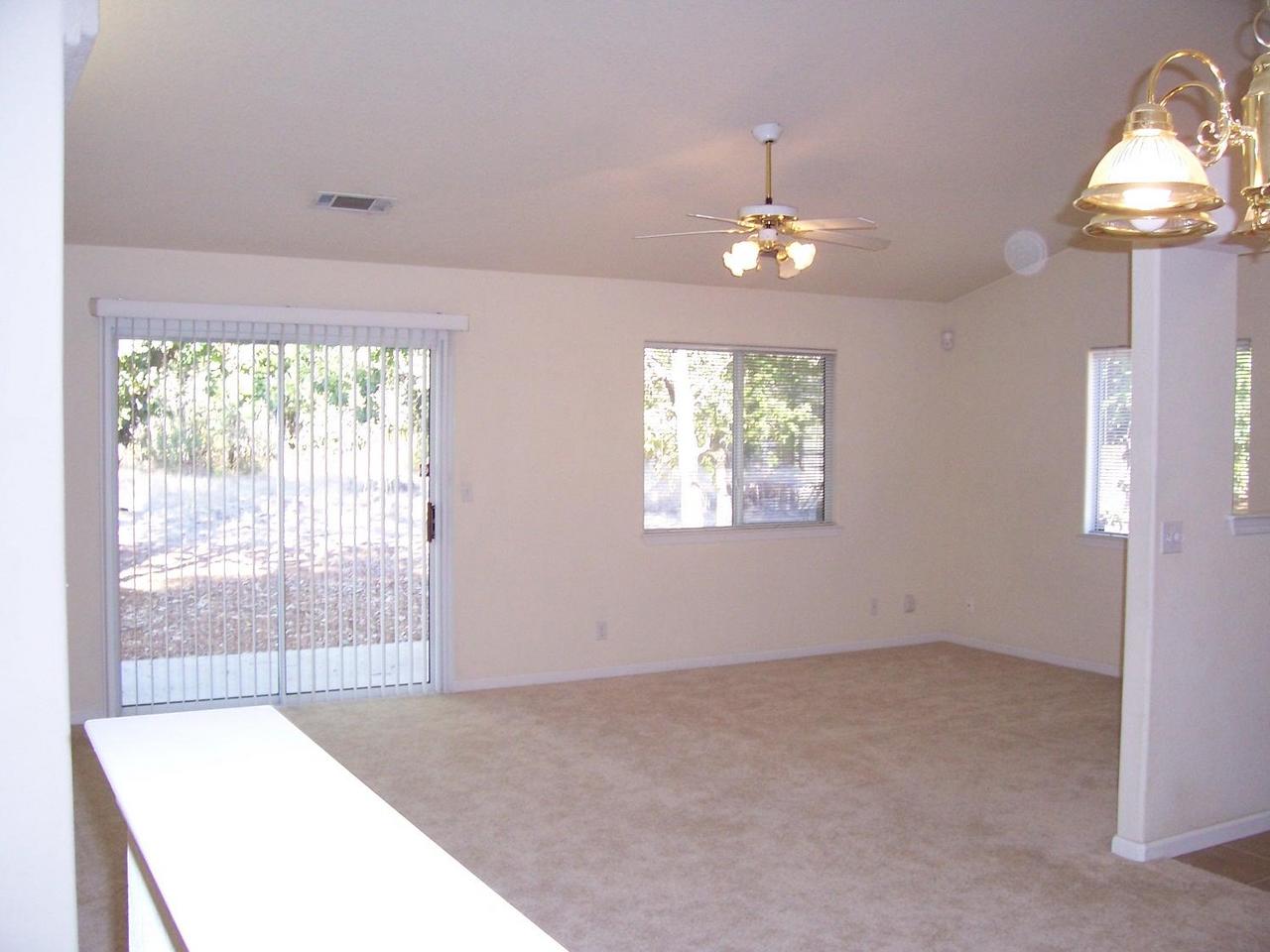 3351 Lawrence Road Redding, CA 96002 - Photo 3 of 8 an empty room with chandelier fan and windows
