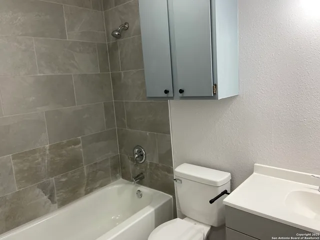 a bath room with a toilet and a bath tub