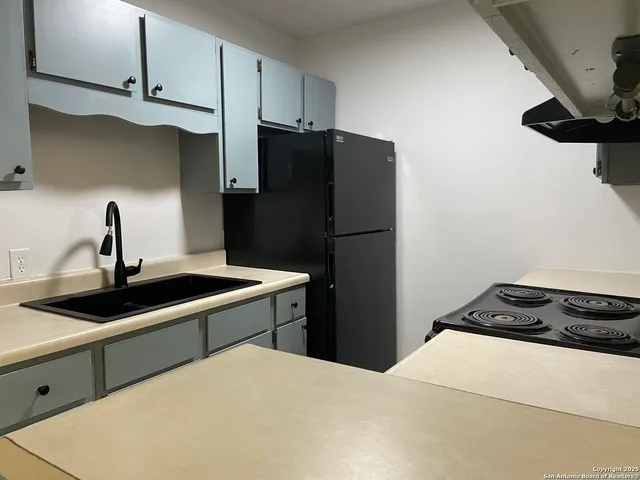 a kitchen with a sink and a refrigerator