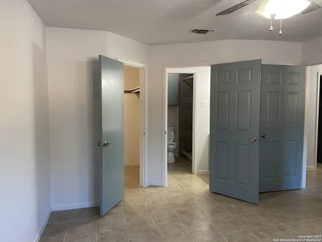 a view of a hallway with closet and a chandelier fan