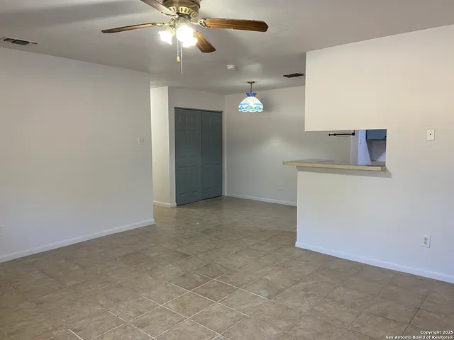 an empty room with a ceiling fan and a bathroom