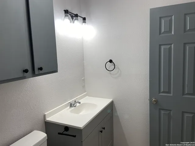 a bathroom with a sink toilet and mirror