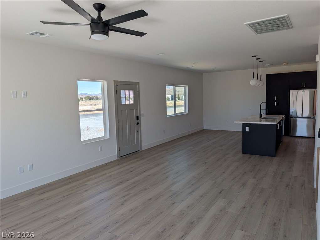 4670 Medicine Man Road Pahrump, NV 89048 - Photo 11 of 36 An open-concept interior features light wood flooring and a modern kitchen with a dark island.
