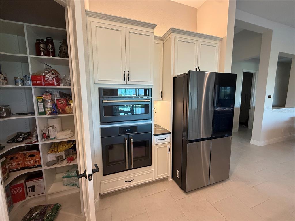 10958 Rustic Timber Loop San Antonio, FL 33576 - Photo 10 of 48 a kitchen with a refrigerator and cabinets