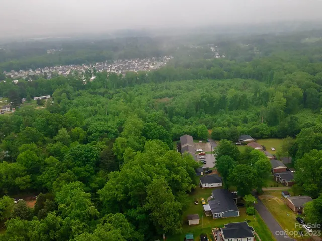 an aerial view of a city with lots of residential buildings and mountain view in back