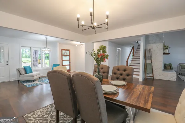 a dining room with furniture large windows and wooden floor