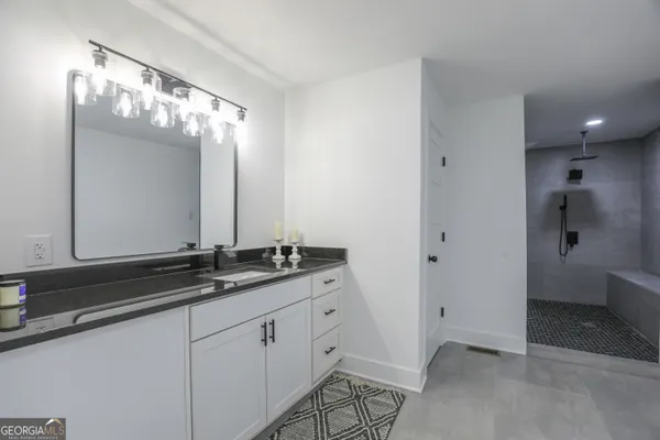 a bathroom with a sink a toilet and shower