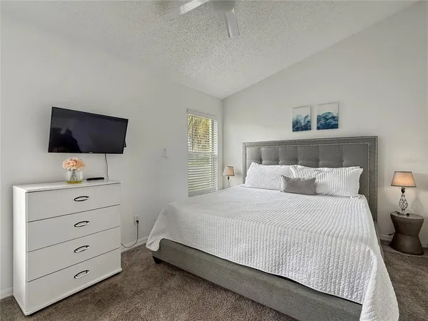 a bedroom with a bed and a flat screen tv