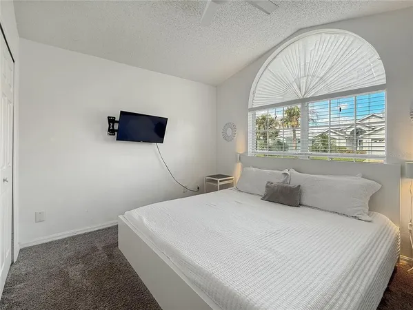 a bedroom with a bed and a large window