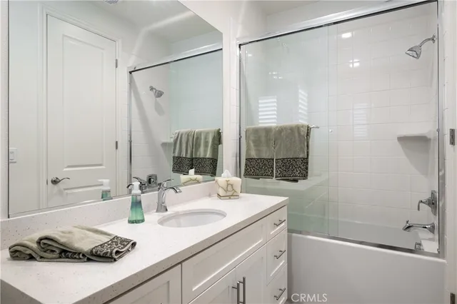 a bathroom with a sink and a mirror with shower