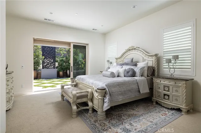 a bedroom with a bed chair and a dresser next to a window